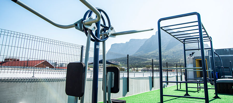 Rooftop gym with gym equipment and view of devils peak