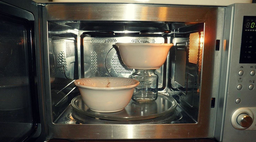 stacking two bowls in a microwave for heating using a glass